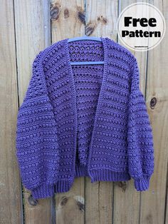 a purple crocheted sweater hanging on a wooden fence with the text free pattern