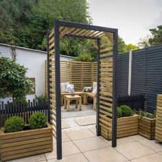 an outdoor garden area with wooden planters and trelliss on the side walk