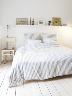 a bedroom with white walls and wooden floors