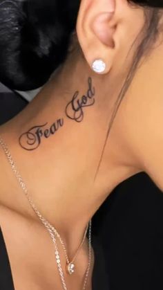 the back of a woman's neck with an inscription that says fear god on it