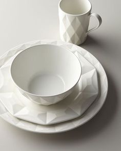 a white plate with two cups on top of it next to a cup and saucer