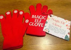 two red mittens with white snowflakes on them and a magic elf glove