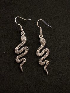 Zinc alloy silver plated snake earrings. Stirling silver earring hooks. ideal gift for a fan of snakes, fantasy, Halloween or goth style.  Comes with rubber safety backs and attached to a display card, protected by sealed plastic packaging. Thank you for looking! 🐍 Silver Fantasy Earrings For Halloween, Snake-shaped Earrings With Ear Wire As Gift, Snake-shaped Earrings With Ear Wire For Gift, Silver Snake-shaped Metal Earrings, Silver Snake Shaped Metal Earrings, Silver Snake Shape Metal Earrings, Silver Snake-shaped Earrings, Silver Snake-shaped Earrings For Pierced Ears, Silver Snake-shaped Pierced Earrings