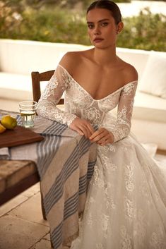 a woman in a wedding dress sitting at a table with lemons on the side