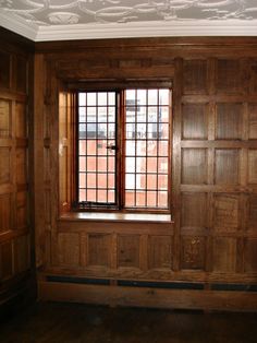 an empty room with wood paneling and wooden doors on the windowsill is shown