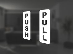 two white push and pull signs hanging from the side of a wall in a living room