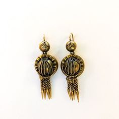 A pair of Victorian era dangle earrings designed during the Etruscan Revival. The earrings have dangling tassels along with foxtail details, wire wrapping, and more. The earrings are gold-tone costume. Traditional Drop Earrings With Lever Back, Traditional Dangle Earrings With French Hook, Bohemian Earrings With French Hook, Bohemian Metal Earrings With Lever Back, Bohemian Drop Earrings With French Hook, Bohemian Brass Linear Earrings For Pierced Ears, Bohemian Earrings With Lever Back Ear Wires, Bohemian Metal Earrings With French Hook, Bohemian Metal Earrings With Lever Back Ear Wires