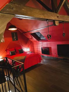 an attic bedroom with red walls and wooden floors