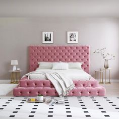 a bedroom with a pink bed and black and white checkered rugs on the floor