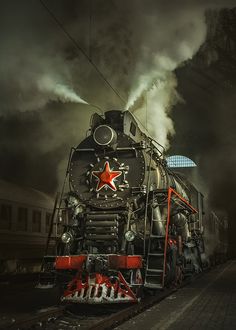 an old steam locomotive with red star on the front