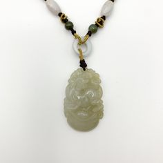 This is a high grade jadeite jade pendant necklace. It is exquisitely hand carved, so each pendant is different in some way. The pendant is completely natural jade, un-dyed and in its natural form. The pendant is carved in the form of the Chinese Zodiac - Dog. The beads above the pendant on the necklace are natural hand carved jadeite jade beads. They may not be perfectly round because they are hand carved. This gives the necklace a more rustic and natural stone like look. The years of the Dog i Engraved Jade Necklaces For Gifts, Engraved Jade Necklace For Gift, Engraved Jade Necklace Gift, Gift Engraved Jade Necklaces, Handmade Jade Necklaces For Good Luck, Traditional Engraved Jade Necklace, Spiritual Jade Medallion Necklace, Handmade Jade Necklace With Flower Pendant, Spiritual Engraved Jade Necklace