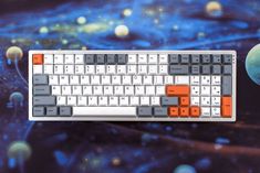 an image of a computer keyboard with space and planets in the background