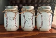 three mason jars with baseballs painted on them