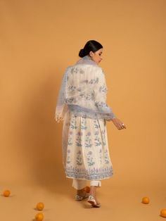 Set of 3 consists of kurta, pants, and dupatta. Reviving the age-old technique of hand block printed florals in lavender and blue set on a majestic bed of ivory soft handwoven cotton. Kurta: Delicately gathered kurta with ghera adorned in hand block printed flowers, 3/4th sleeves, and silver gota detailing on the hemline & sleeves, set in pure cotton Dupatta: Handwoven kota doria dupatta, complete with customized block prints Pants: Ivory straight-fit pants in soft cotton. Fit: Fitted at bus Bohemian Cotton Silk Set With Sheer Dupatta, Bohemian Set With Sheer Dupatta In Cotton Silk, Unstitched Bohemian Kurta With Sheer Dupatta, Bohemian Anarkali Set With Sheer Dupatta And Straight Kurta, Bohemian Salwar Kameez With Sheer Dupatta In Mulmul, Traditional Salwar Kameez With Floral Print For Transitional Season, White Chanderi Palazzo Set With Block Print, Bohemian Lawn Suit With Sheer Dupatta And Straight Kurta, Traditional Cotton Kurta With Sheer Dupatta