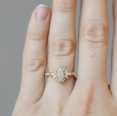 a woman's hand with a diamond ring on top of her finger and an engagement band