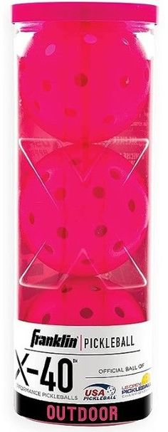 the pink pickleball is packed in a clear plastic container with black dots on it