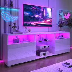 an entertainment center with purple lighting and electronics on the shelves, in front of a flat screen tv