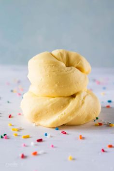 three doughnuts stacked on top of each other with sprinkles around them