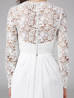 the back of a woman's white dress with lace detailing and long sleeves,