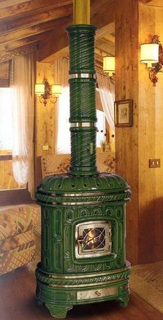 a green stove sitting in the middle of a living room next to a couch and window