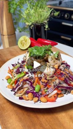 a white plate topped with meat and veggies on top of a wooden table