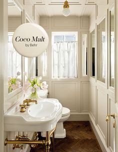 a bathroom with white walls and wood flooring next to a sink, toilet and mirror