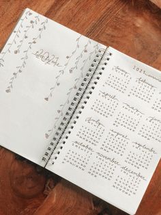 a spiral bound calendar on top of a wooden table