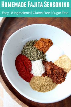 a white bowl filled with spices on top of a wooden table