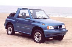 a blue pick up truck parked on the beach