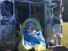 a man sitting in the back of a truck covered in blue and yellow plastic wrap