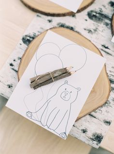 a pencil sitting on top of a piece of paper next to some wood slices and other items