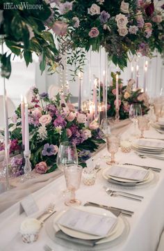 the table is set with flowers and candles for an elegant dinner party or wedding reception