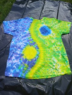 a tie - dyed shirt laying on top of a tarp