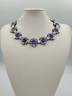 Each piece of our statement necklaces is handmade and one of a kind made in Italy. Our creations is made of high quality materials such as crystals and rhinestones. Each embroidered material is carefully hand sewn. Very glamorous and stylish. Perfect gift to someone you like. Materials Strass stones in Crystal rinbow and  Violet Blue color in different shape and dimension.  Black eco leather backing. Aluminium color hook closure. Measurements Weight approximate 150 grams. Circumference approximate 59 cm - 23,22 in Feel free to contact us if you have any question. Thank you so much for looking at our shop and our articles each of them, single piece. Handmade Crystal Necklaces For Parties, Evening Jeweled Crystal Necklace, Evening Crystal Necklace, Evening Crystal Jeweled Necklaces, Crystal Jeweled Costume Jewelry Necklaces, Evening Jeweled Choker Necklace, Crystal Beaded Necklaces With Jewels For Party, Crystal Beaded Necklace With Jewels For Party, Party Choker Necklace With Stones