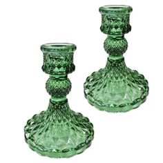 two green glass candlesticks sitting next to each other