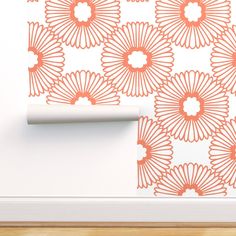 an orange flower wall decal on a white wall next to a roll of toilet paper