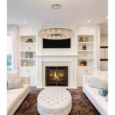 a living room filled with furniture and a fire place in front of a tv mounted on a wall