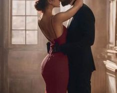 a woman in a red dress and a man in a tuxedo kissing each other