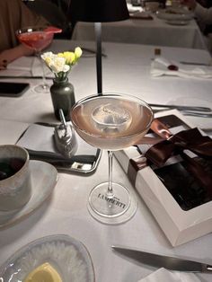 a table topped with plates and cups filled with desserts on top of a white table cloth