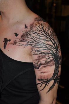 a man with a tree and birds tattoo on his chest