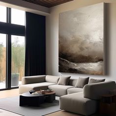 a living room filled with furniture and a large painting on the wall above it's windows