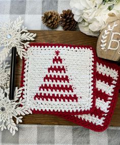 a crocheted christmas tree placemat with snowflakes and pineconis