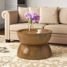 a living room with a couch, coffee table and flowers