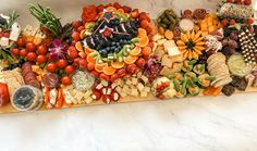 an assortment of fruits and vegetables on a cutting board