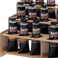 several different types of oil on display in a wooden holder with black and red labels