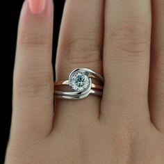 a woman's hand with two rings on it and a diamond in the middle