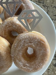 several sugared doughnuts on a plate with a diamond cutout in the middle