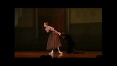 a woman in a brown dress is dancing on stage