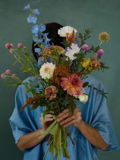 a woman holding a bouquet of flowers in her hands