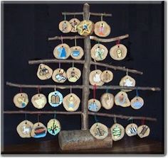 a wooden christmas tree with ornaments hanging from it's branches on a black background